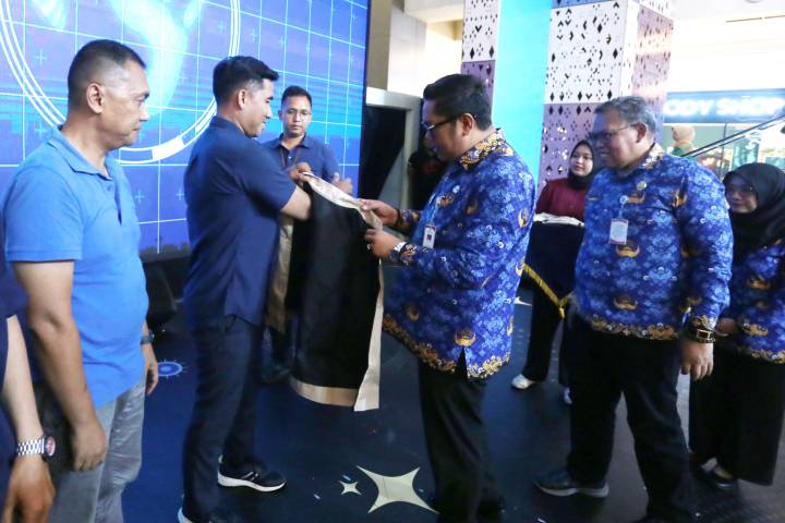 Wakil Wali Kota Tangerang, H. Maryono Hasan didampingi Asisten, H. Deni Koswara dan Kadis Kesehatan, dr. Dini Anggraeni, menyematkan jaket kepada salah satu perseta yang mengikuti kegiatan peringatan Hari AIDS Sedunia 2025.