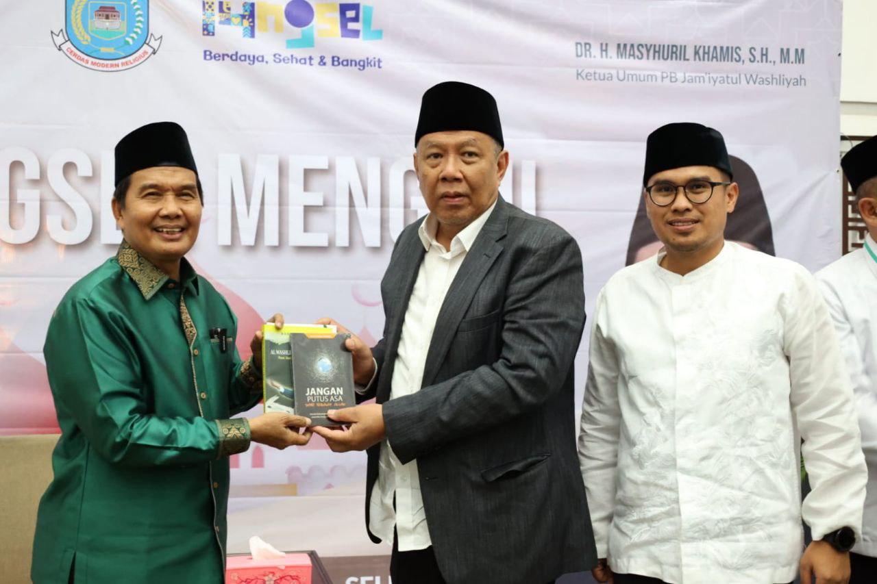 Ketua Umum PB Al-Jam'iyatul Washliyah, DR. H. Masyhuril Khamis saat memberikan buku kepada Wali Kota Benyamin Davnie, dan Wakil Wali Kota Pilar Saga Ichsan.