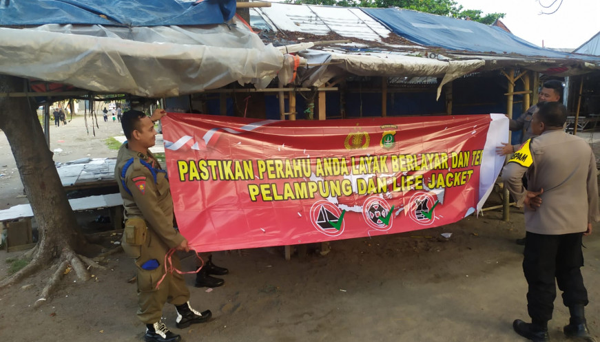 Satpol PP saat memasang spanduk pemberitahuan untuk pengunjung wisata.