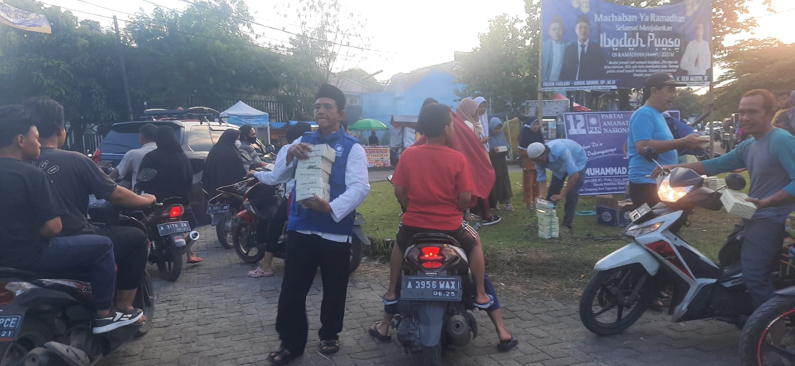 Relawan Muhammad Rizal saat memberikan makanan takjil kepada masyarakat pengguna jalan.