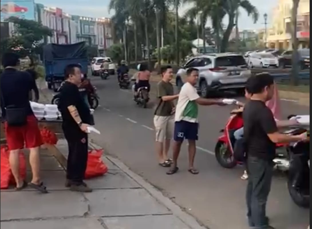 Menejemen Trenz saat membagikan takjil kepada masyarakat pengguna jalan raya.