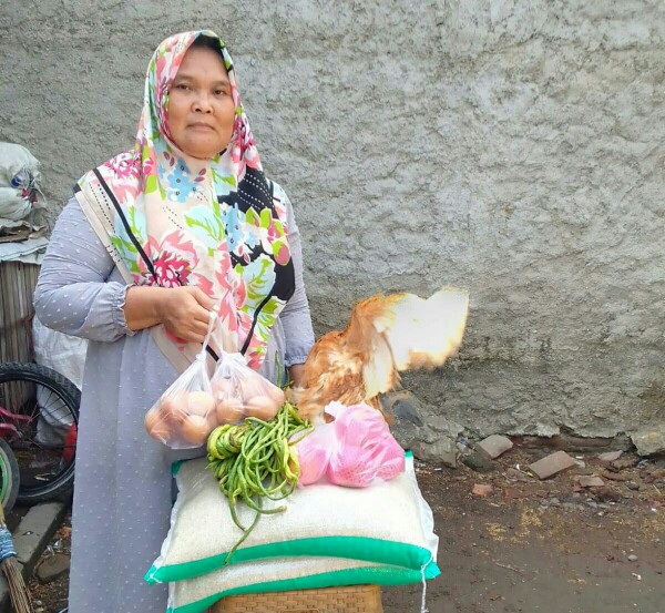 Ibu Elvi saat menunjukan bantuan sembako BPNT yang didapatkannya.