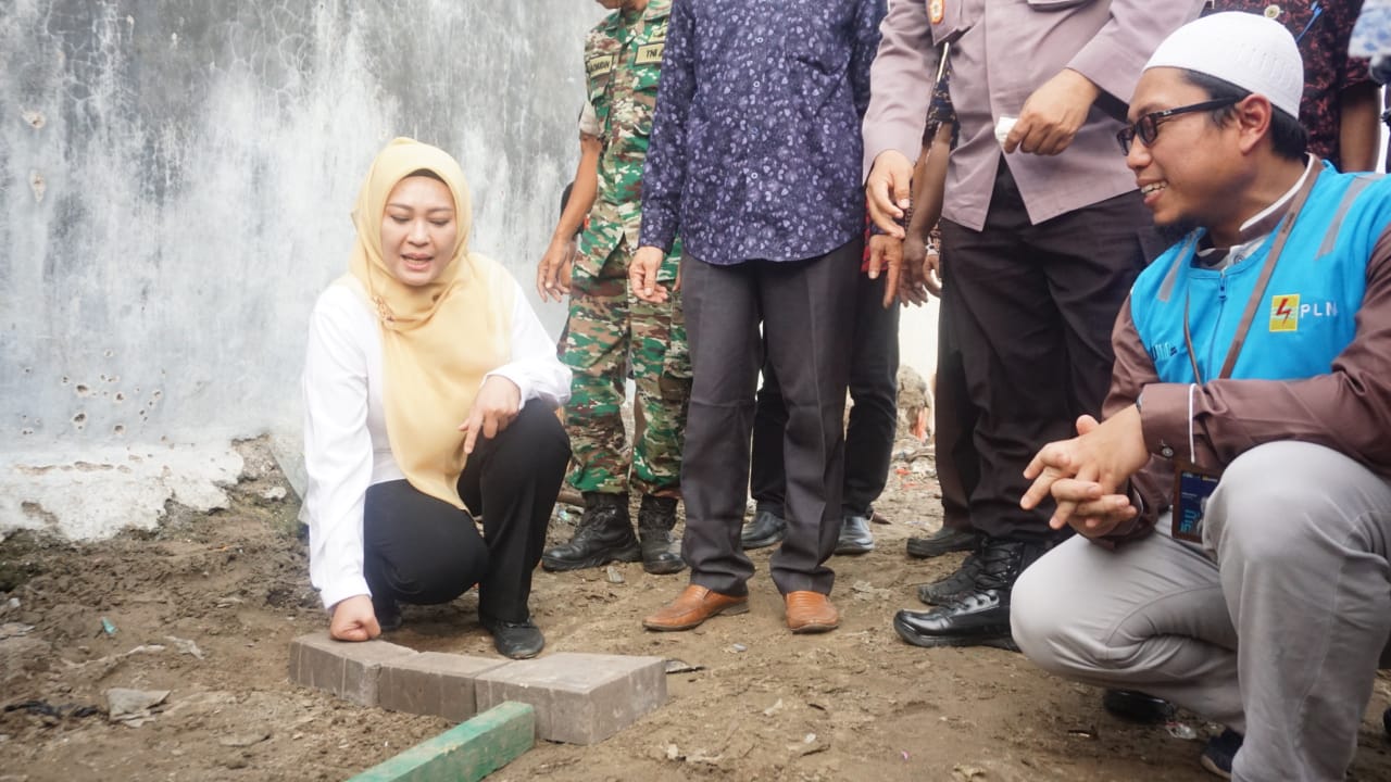 Bupati Irna saat memasang paving blok.