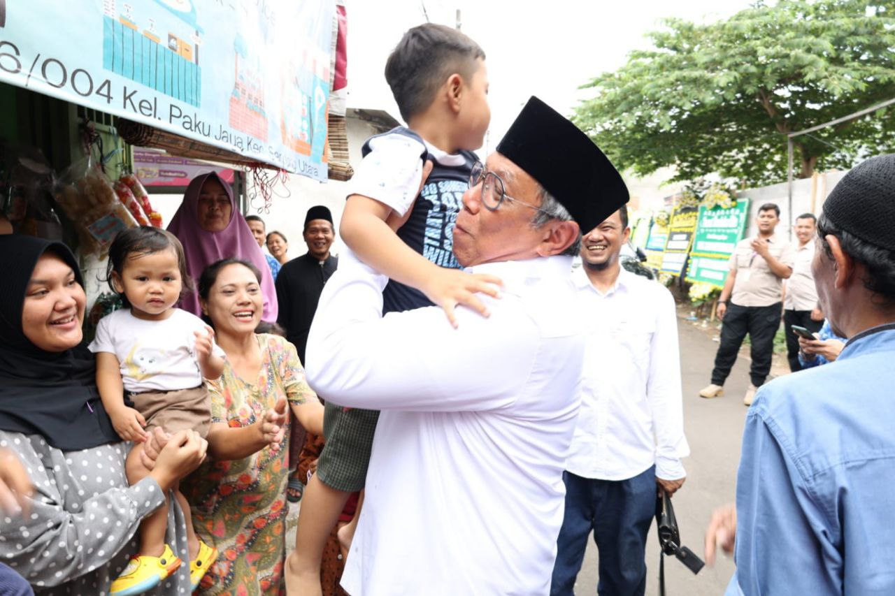 Benyamin saat menggendong anak korban yang meninggal kecelakaan bus di Guci Tegal.