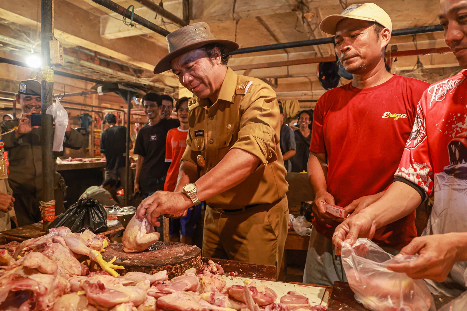 Al Muktabar saat jadi tukang potong ayam dadakan di Pasar Rau.