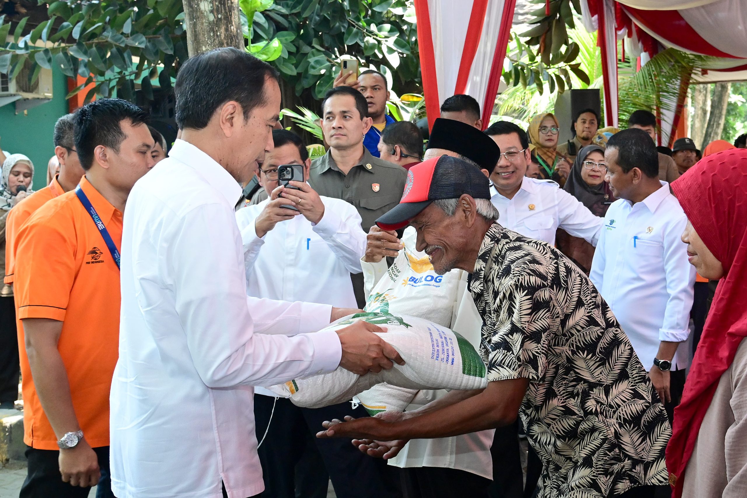 Jokowi saat menyerahkan beras ke masyarakat.