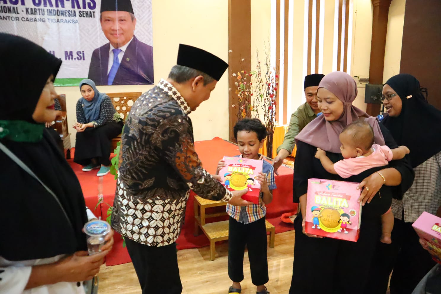 Dewan Muhammad Rizal saat memberikan biskuit makanan bergizi untuk ibu hamil dan balita.