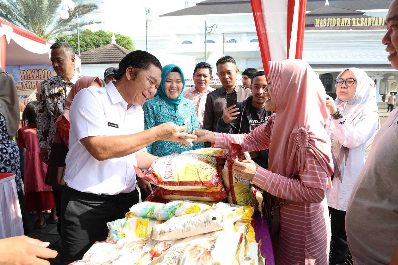 Pj Al Muktabar saat melayani pembeli beras.