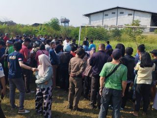 Warga saat melihat polisi mengevakuasi orang yang gantung diri di lapangan sepak bola Jatiuwung.