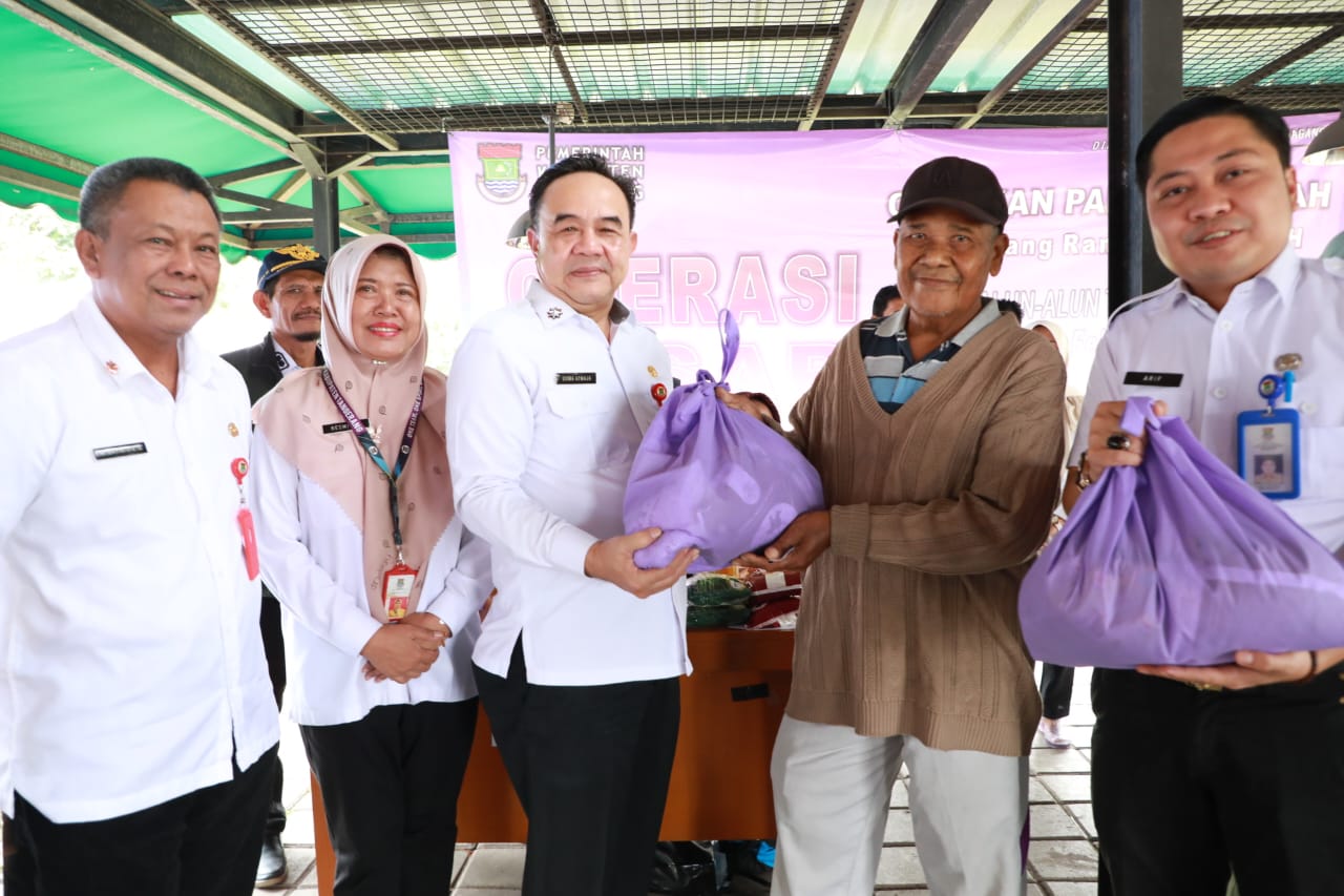 Sekda Soma Atmaja di dampingi jajarannya saat melayani warga yang membeli paket sembako.