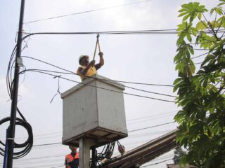 Petugas saat menata kabel yang semrawut.