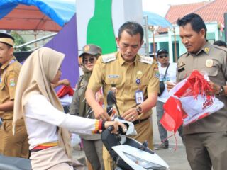 Camat Rudi Hadikarsono saat membagikan bendera merah putih ke pengguna jalan di kecamatan kemiri.
