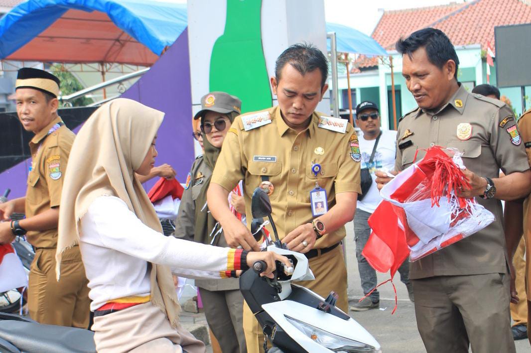 Camat Rudi Hadikarsono saat membagikan bendera merah putih ke pengguna jalan di kecamatan kemiri.