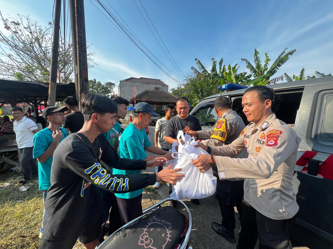 Polisi saat memberikan paket sembako ke masyarakat.