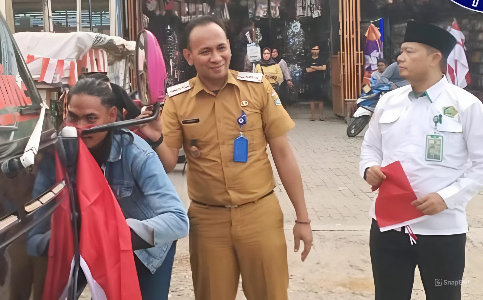 Camat Kurnia saat memberikan bendera merah putih ke pengguna jalan di Kecamatan Teluknaga.