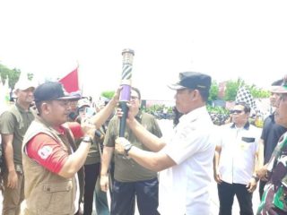 Camat Yusuf saat menerima obor dari Camat Dadang pada kirab Obor Abadi Porkab VI Kabupaten Tangerang 2025.