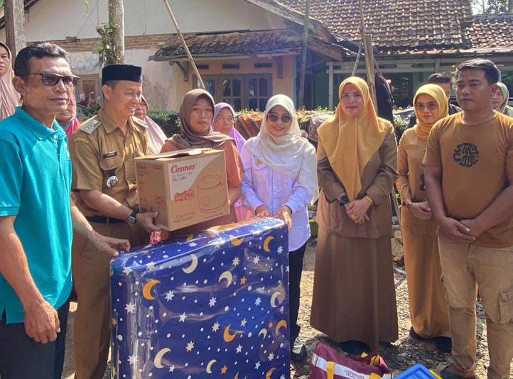Bupati Dewi saat menyerahkan bantuan untuk warga yang rumahnya kebakaran.