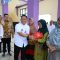 Wabup Intan bersama Camat Dadang saat langsung melayani warga yang mengikuti gerakan pangan murah.