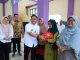 Wabup Intan bersama Camat Dadang saat langsung melayani warga yang mengikuti gerakan pangan murah.