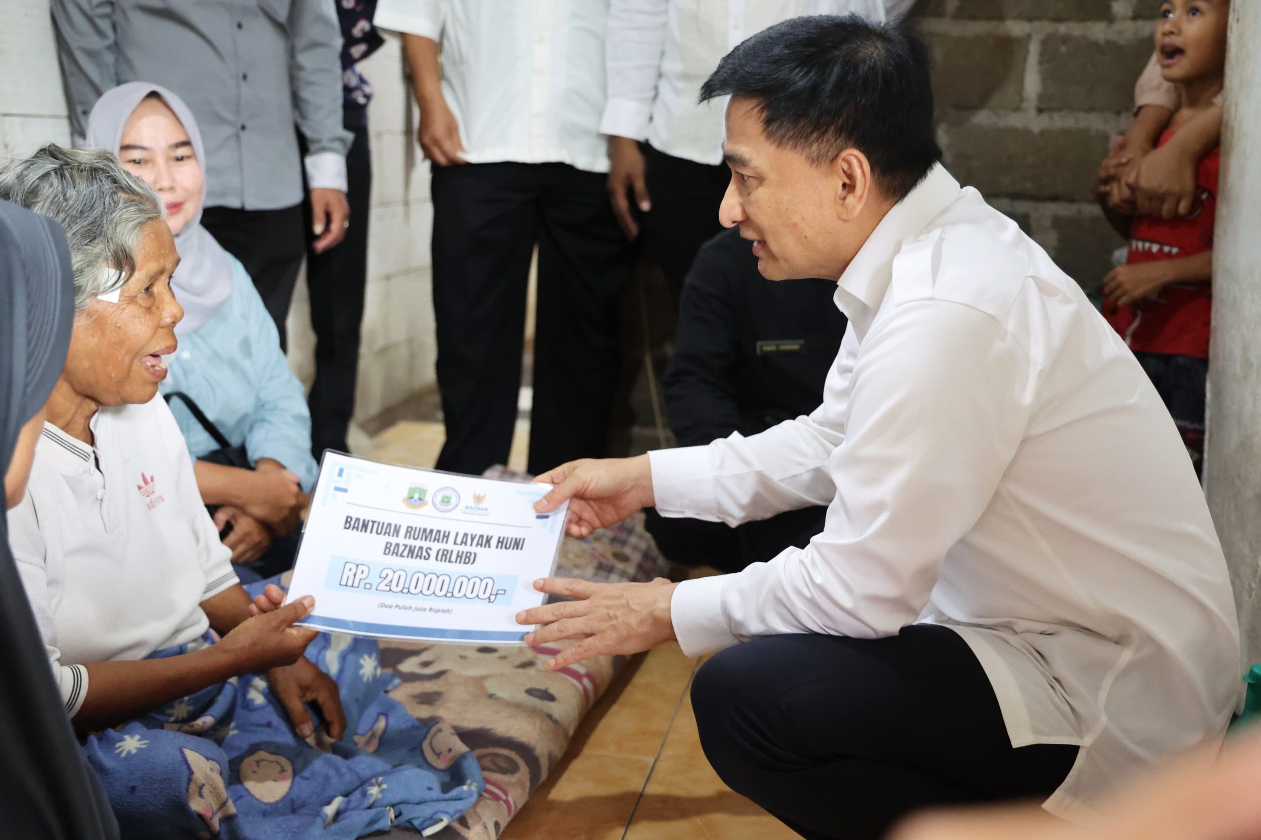 Wagub Dimyati saat memberikan bantuan untuk seorang ibu lansia.