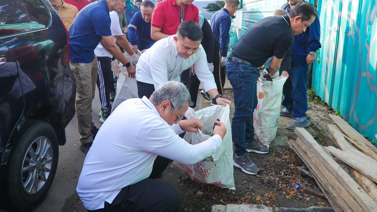 Benyamin-Pilar bersama Menteri Hanif Faisol Nurofiq saat membersihkan sampah di jalan raya.