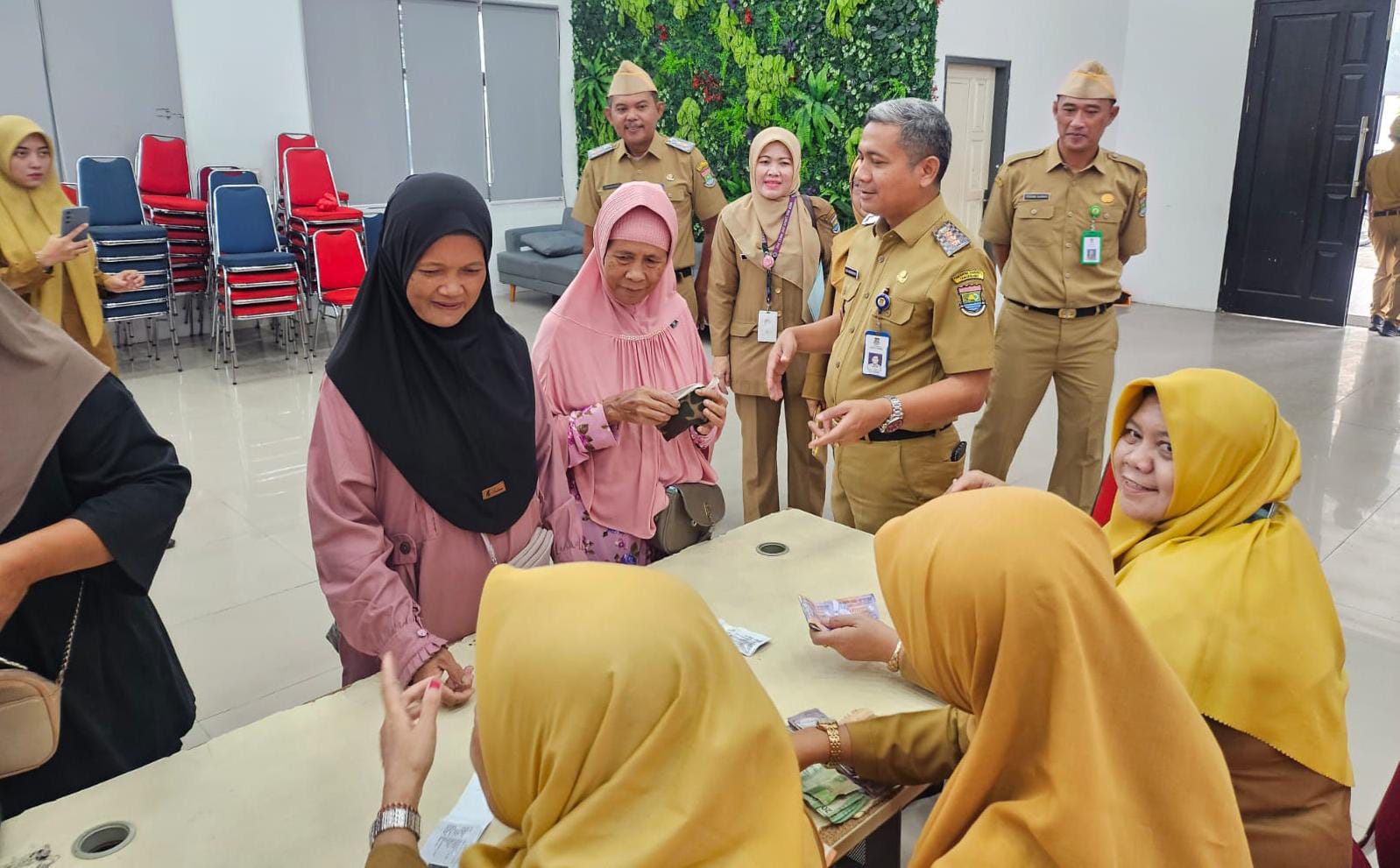 Camat Cucu Abdurosyied saat melayani warga yang mengikuti gerakan pasar murah di Kecamatan Tigararaksa.