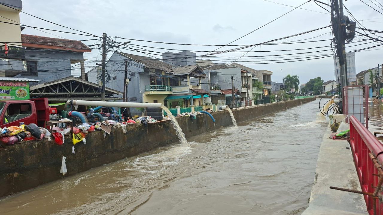 Tampak Pompa air sedang membuang air ke kali.