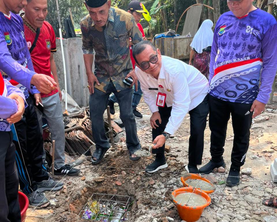 Kepala Dinas Iwan Firmansyah saat meletakan batu pertama pembangunan rumah Ibu Laila di Kecamatan Gunung Kaler.