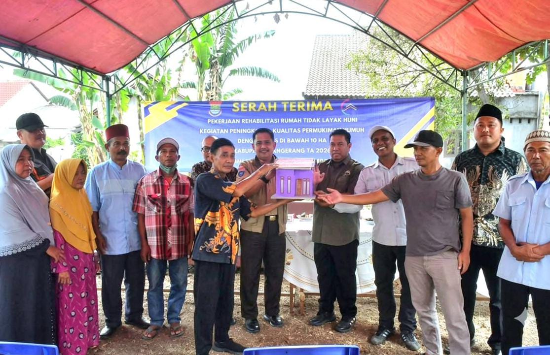 Camat Kelapa Dua Dadang Sudrajat saat simbolis menyerahkan hasil program bedah rumah untuk warga.